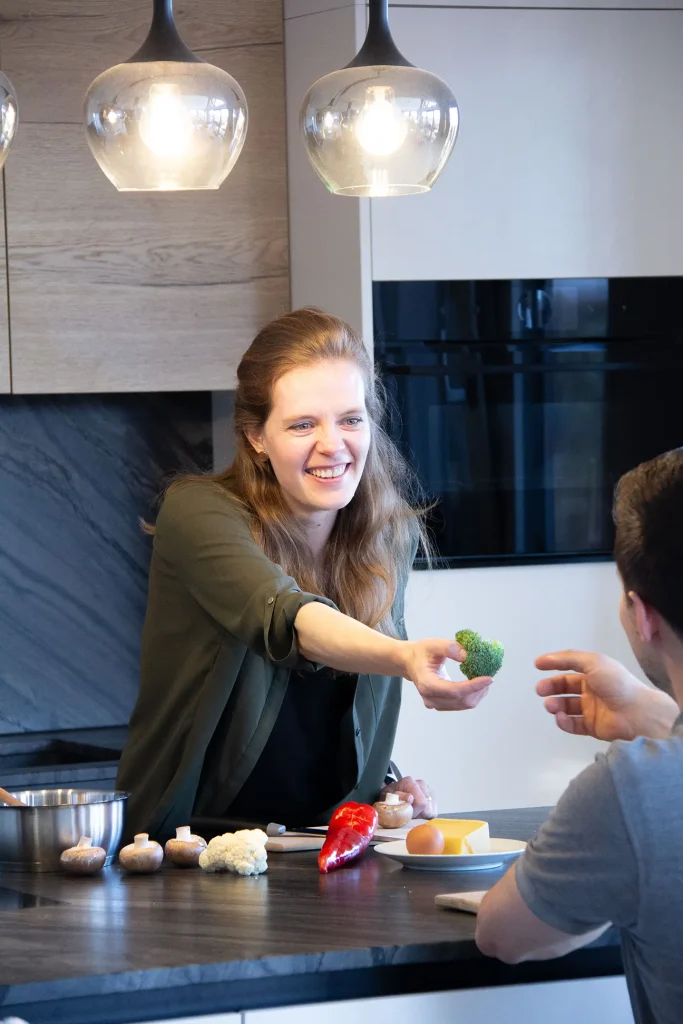 Diätologie Graz - Valentina Wagner reicht in der Küche Gemüse über die Theke